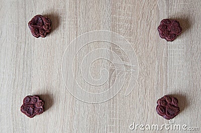 appetizing dog muffins on wooden background. dog birthday. red velvet. paw shaped dog treat. homemade dog biscuit. paw bakery Stock Photo