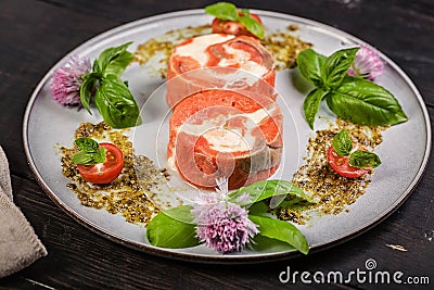 Appetizing pink salmon roll with cream cheese and shrimp meat with ricotta pesto sauce with fresh basil. Delicious seafood Stock Photo