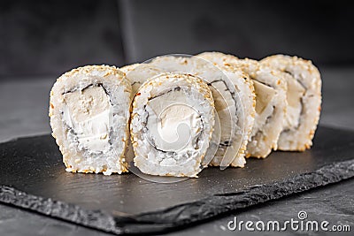 Appetizing sushi roll with Philadelphia tofu sesame cheese on a black stone plate Stock Photo