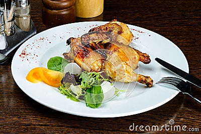 Appetizing spicy baked mini chicken on the plate in Italian rest Stock Photo