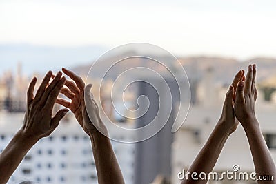 Applause to medical staff. Family clapping hands, applauding from balcony to support doctors, nurses, hospital workers Stock Photo