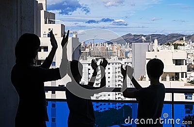 Applause to medical staff. Family clapping hands, applauding from balcony to support doctors, nurses, hospital workers Stock Photo