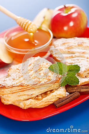 Apple cakes on plate, honey and apple pieces around Stock Photo