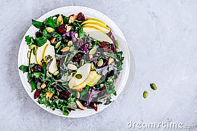 Apple Cranberry Kale Salad bowl with dry cranberries, almonds and pumpkin seeds Stock Photo