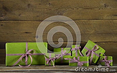 Apple green presents with red and white checked ribbon on wooden Stock Photo