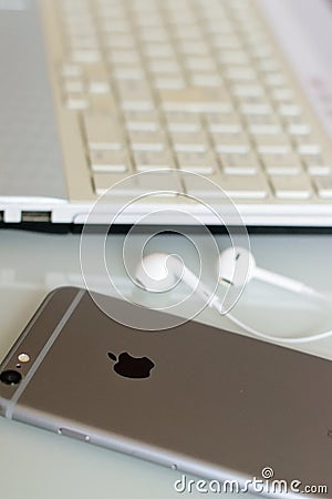 Apple iPhone on desk with wired earphones Editorial Stock Photo