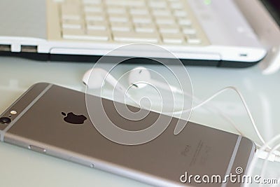 Apple iPhone on desk with wired earphones Editorial Stock Photo