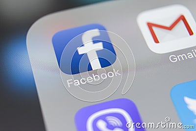 Apple iPhone 8 with Facebook icon on monitor screen. Facebook one of the biggest social network website. Icon of Facebook.com Editorial Stock Photo