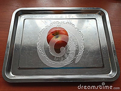 Apple on iron tray on wooden table Stock Photo