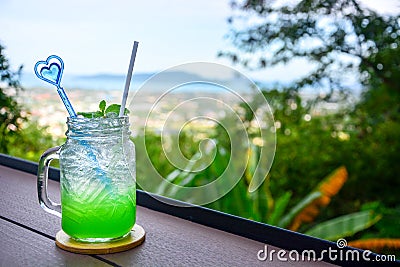 Apple Italian soda with mint leaf on wooden table with natural blur background, copy space Stock Photo
