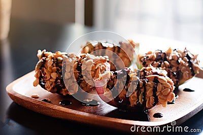 Apple with peanut butter,cereal and chocolate caramel topping,put on wooden dish,prepare for serving Stock Photo