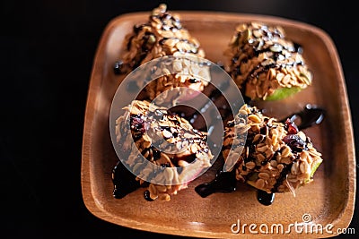 Apple with peanut butter,cereal and chocolate topping Stock Photo