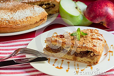 Apple pie with nuts and raisins drizzled with caramel syrup. Stock Photo