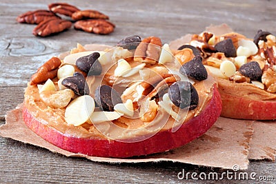 Apple rounds close up with peanut butter, chocolate and nuts Stock Photo