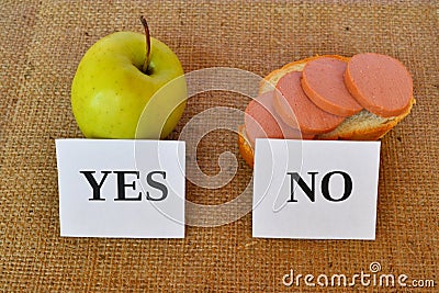 An apple and a sandwich with sausage - useful and harmful snacks Stock Photo