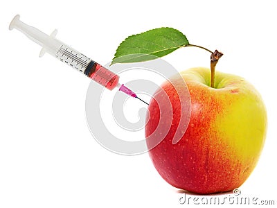 Apple stuck with syringe, Concept of genetic modification of fruits Stock Photo