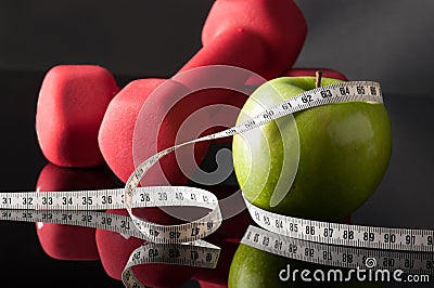 apple and dumbells surrounded by tapeline Stock Photo