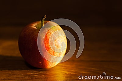 Apple on table illuminated by afternoon sunlight Stock Photo