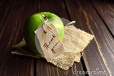 Apple with thank you lable on a piece of burlap over dark wooden background. Happy thanksgiving day concept. Stock Photo