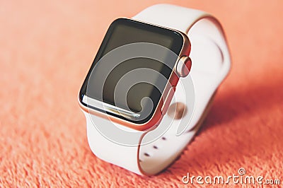 Apple Watch Gold on a soft fluffy peach-colored background Editorial Stock Photo