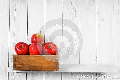 Apples in a box on wooden shelf. Stock Photo