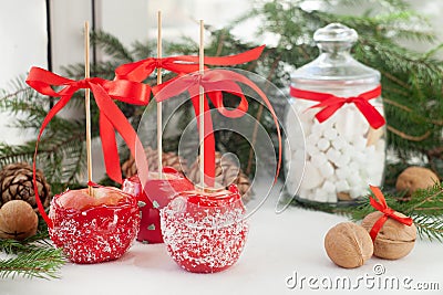 Apples dip in red sugar icing and coconut chips, Candies, sweets and desserts on Xmas time. Stock Photo