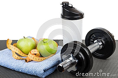 Apples, measures tape on blue towel, plastic shaker and dumbbell Stock Photo