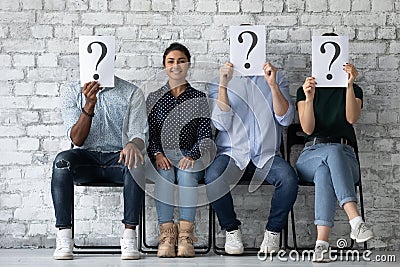 Applicant sit with competitors people hiding faces behind question marks Stock Photo