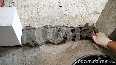 Applying mortar to the floor, for laying blocks. Gluing aerated concrete blocks with glue and putty. Applying mortar to Stock Photo