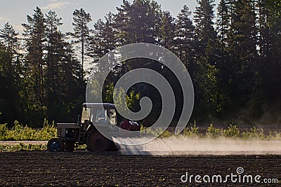 Application of chemical fertilizers to crops by spraying, which is carried out by an agricultural tractor with built-in Stock Photo