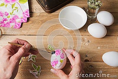 Apply woman PVA glue on colored Easter egg, technique of decoup Stock Photo