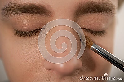 Applying concealer on man to cover dark circles Stock Photo