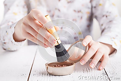 Applying cosmetic with a big brush. Girl gets blush on the cheek Stock Photo