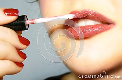 Applying the lip gloss Stock Photo