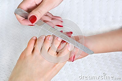 Applying pedicure, using nail file Stock Photo