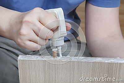 Applying wood glue, carpenter gluing wooden parts for furniture, close-up. Stock Photo