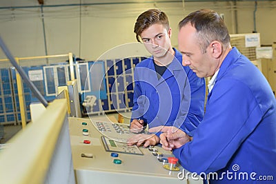 Apprentice being taught controls machine Stock Photo