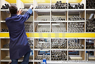 Apprentice Checking Stock Levels In Store Room Stock Photo