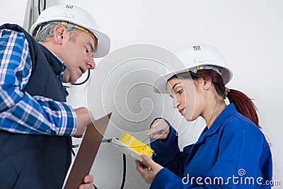 Apprentice electrician unscrewing junction box Stock Photo