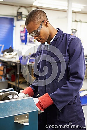 Apprentice Engineer Working On Factory Floor Stock Photo