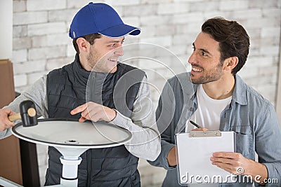 apprentice handyman using mallet to locate rubber seal into groove Stock Photo