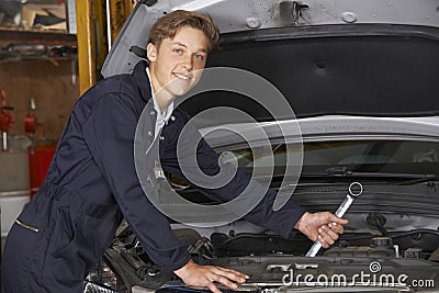 Apprentice Mechanic In Auto Shop Working On Car Engine Stock Photo