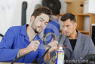 Apprentice mechanic being assessed while working Stock Photo
