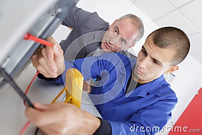 apprentice technician testing electronic equipment in service centre Stock Photo