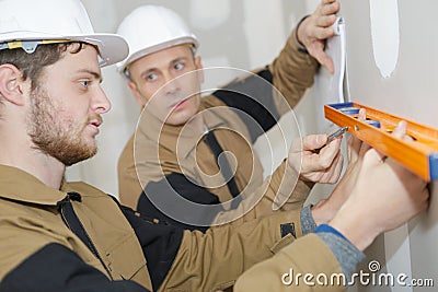 Apprentice workman with spirit level Stock Photo