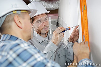 Apprentice workman with spirit level Stock Photo