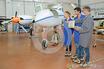 Apprentices and an aircraft Stock Photo