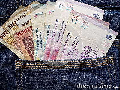 approach to front pocket of jeans in blue with argentinean banknotes Stock Photo
