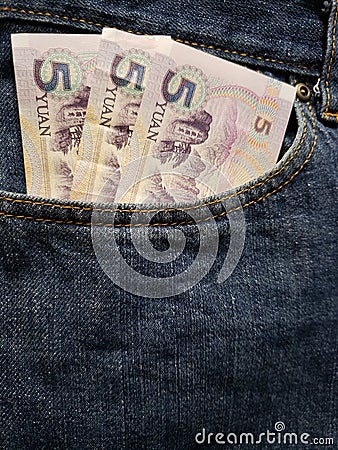 approach to front pocket of jeans in blue with Chinese banknotes Stock Photo