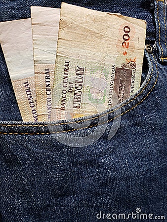 approach to front pocket of jeans in blue with uruguayan banknotes Stock Photo